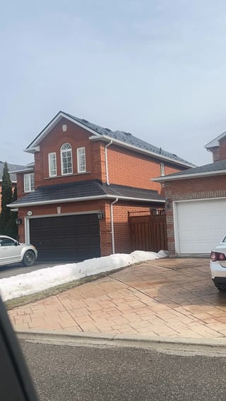 Black Interlock Slate aluminum roof on a brick house with a metal roof in a suburban area, Mississauga, Ontario