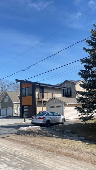 Tudor Brown Interlock Cedar Shingle aluminum roof on a brown Tudor home with dormers among tall trees, Innsifil, Ontario