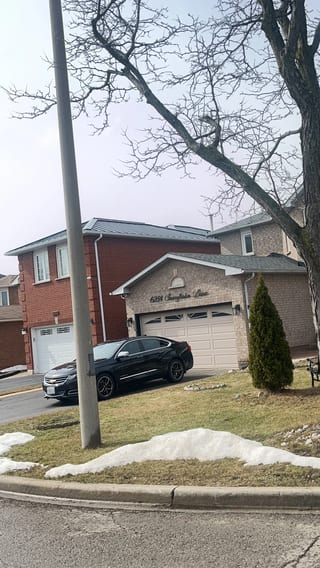 Black Interlock Standing Seam aluminum roof on a tan two-storey home with dormers in a suburban, Mississauga, Ontario