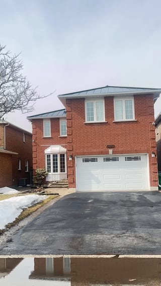 Black Interlock Standing Seam aluminum roof being installed on a red brick house with a metal roof in an urban/suburban, Mississauga, Ontario