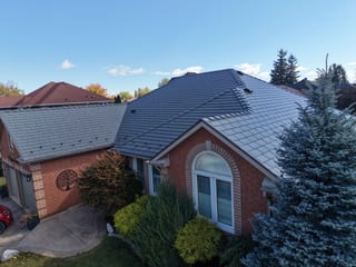Musket Grey Interlock Cedar Shingle aluminum roof on a red brick single-family home with a metal roof in a, Brampton, Ontario