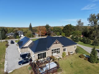 Black Interlock Slate aluminum roof on a tan home with a black metal roof in a rural setting, Blackstock, Ontario