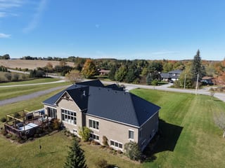 Black Interlock Slate aluminum roof on a beige single-storey home with a black metal roof in a, Blackstock, Ontario