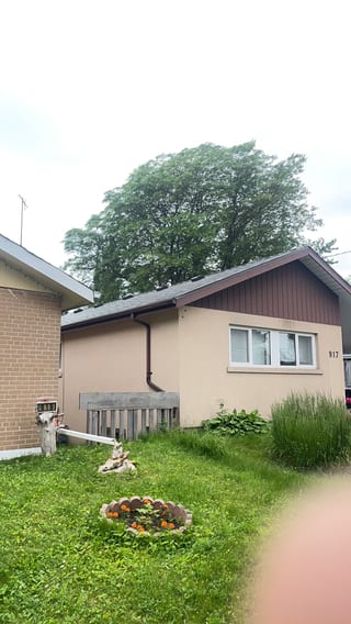 Single-storey ranch home at 917 with Interlock Musket Grey aluminum slate roofing on a simple gable, stucco exterior, Scarborough ON.