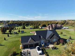 Black Interlock Slate aluminum roof on a beige ranch-style home among trees and green grass, Kawartha Lakes, Ontario