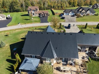 Black Interlock Slate aluminum roof on a black ranch-style home among tall trees in the Kawartha, Kawartha Lakes, Ontario