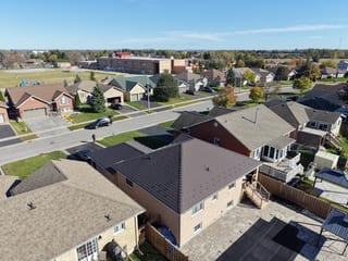 Tudor Brown Interlock Slate aluminum roof on a tan home with brown roof in a rural suburban neighbourhood, Lindsay, Ontario