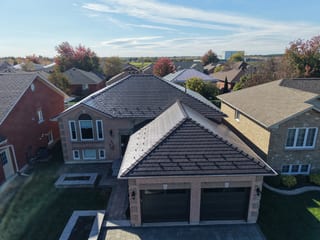Tudor Brown Interlock Slate aluminum roof on a two-storey Tudor home with dormers in a suburban setting, Lindsay, Ontario