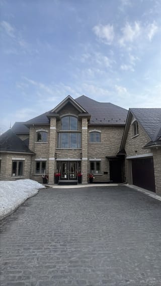 Tudor Brown Interlock Slate aluminum roof on a light brown two-storey home with a gable roof in a rural, Sudbury, Ontario