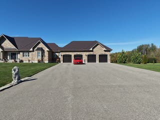 Tudor Brown Interlock Slate aluminum roof on a Tudor home with a brown metal roof in a wooded area, Kawartha Lakes, Ontario