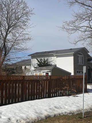 Charcoal Grey Interlock Shingle aluminum roof on a two-storey home with a grey metal roof and a snowy yard, Gloucester, Ontario