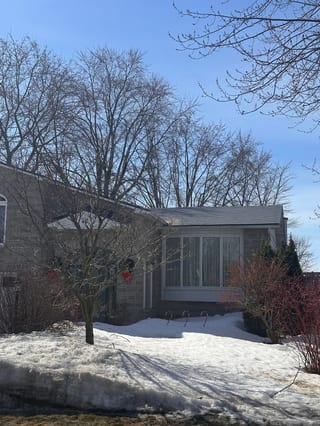 Charcoal Grey Interlock Shingle aluminum roof being installed on a grey single-family home with dormers in a forested rural, Gloucester, Ontario
