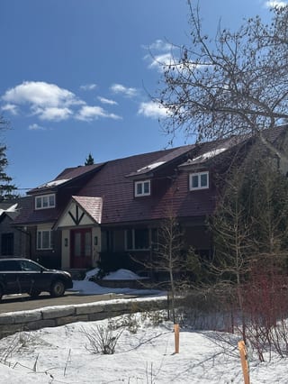 Tile Red Interlock Shingle aluminum roof on a red two-storey house with a metal roof in a snowy, Stittsville, Ontario