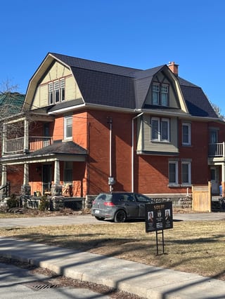 Black Interlock Slate aluminum roof on a red two-storey home with dormers in a suburban, Kemptville, Ontario