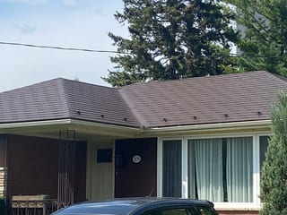 Colonial Brown Interlock aluminum shingle roof on a 1-storey ranch-style brick home in Ottawa, featuring a hip roof with snow guards.