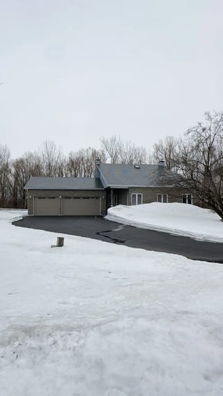 Black Interlock Slate aluminum roof on a rural home with a grey metal roof and attached garage in, Navan, Ontario