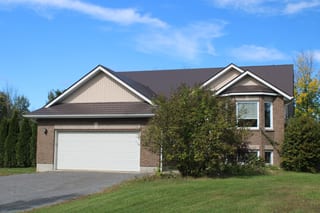 Tudor Brown Interlock Slate aluminum roof on a brown Tudor-style home with dormers in a suburban setting, Kingston, Ontario