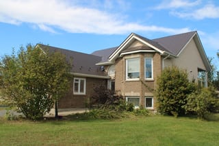 Tudor Brown Interlock Slate aluminum roof on a two-storey Tudor home with a brown roof in a suburban area, Kingston, Ontario