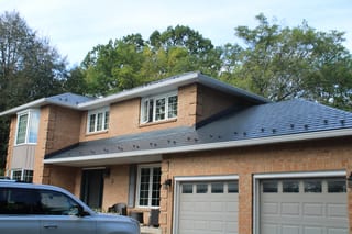 Deep Charcoal Interlock Slate aluminum roof on a two-storey brick home with a garage and dormers among, Kingston, Ontario