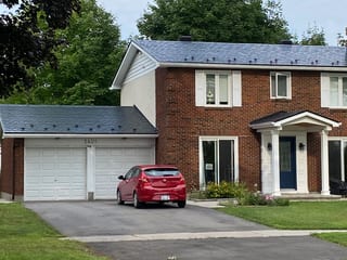 Black Interlock Slate aluminum roof on a brick two-storey home with a metal roof in a suburban area, Ottawa, Ontario