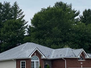 Black Interlock Slate aluminum roof on a red brick home with a metal roof in a wooded suburb, Pembroke, Ontario
