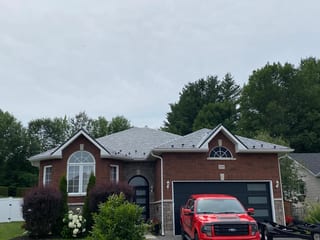 Black Interlock Slate aluminum roof on a red home with a metal roof in a wooded area, Pembroke, Ontario