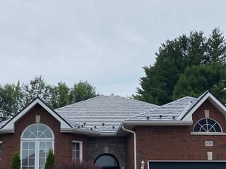Black Interlock Slate aluminum roof on a red brick single-family home with a metal roof in rural, Pembroke, Ontario