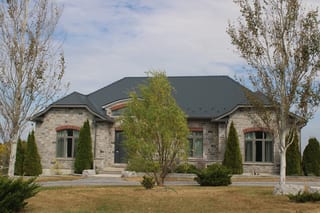 Deep Charcoal Interlock Slate aluminum roof on a stone ranch home with a metal roof in a rural setting, Picton, Ontario