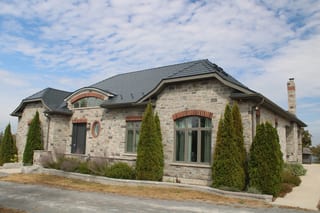 Deep Charcoal Interlock Slate aluminum roof on a beige one-storey ranch with a gable roof among rural, Picton, Ontario