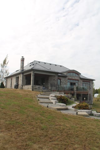 Deep Charcoal Interlock Slate aluminum roof on a Deep Charcoal metal roof on a stone house in a rural, Picton, Ontario