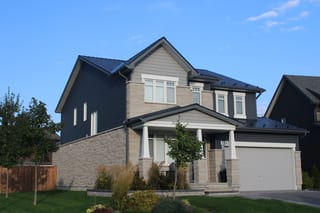 Black Interlock Slate aluminum roof on a two-storey home with grey siding and stone accents in a, Carleton Place, Ontario