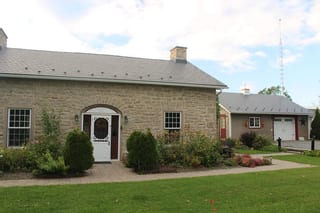 Deep Charcoal Interlock Slate aluminum roof on a tan one-storey home with stone facade and a grey metal, Carleton Place, Ontario