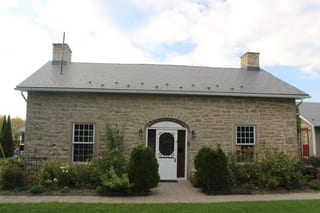 Deep Charcoal Interlock Slate aluminum roof on a brown single-storey cottage with dormers in a rural, Carleton Place, Ontario