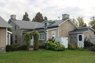 Deep Charcoal Interlock Slate aluminum roof on a tan home with white trim and a metal roof in a rural, Carleton Place, Ontario