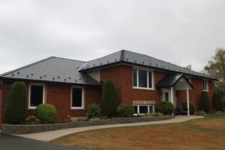Black Interlock Slate aluminum roof on a red brick house with a metal roof in a rural setting, Carrying Place, Ontario