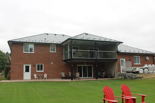 Black Interlock Slate aluminum roof on a red brick house with a metal roof on a rural property, Carrying Place, Ontario
