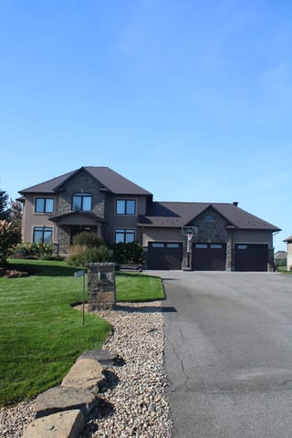 Tudor Brown Interlock Cedar Shingle aluminum roof on a Tudor brown roof on a two-storey house in a rural setting, Greely, Ontario
