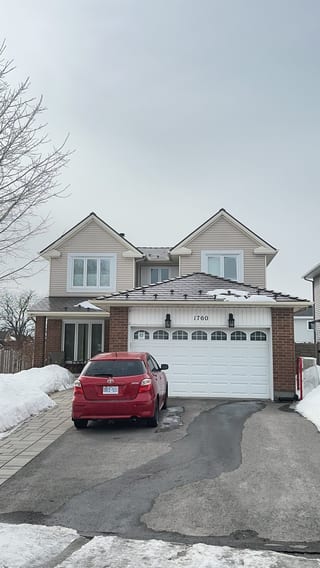 Two-storey colonial-style home in Ottawa with Interlock Colonial Brown aluminum slate metal roofing, twin dormers, and brick facade, photographed in winter.