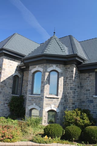 Deep Charcoal Interlock Slate aluminum roof on a grey stone colonial home with a grey metal roof, Alexandria, Ontario