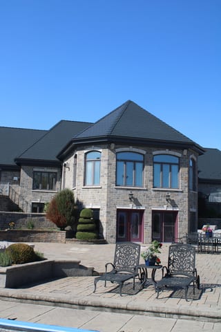 Deep Charcoal Interlock Slate aluminum roof on a stone house with a slate metal roof in a suburban, Alexandria, Ontario