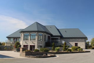 Deep Charcoal Interlock Slate aluminum roof on a two-storey home with a metal roof and stone facade in a, Alexandria, Ontario