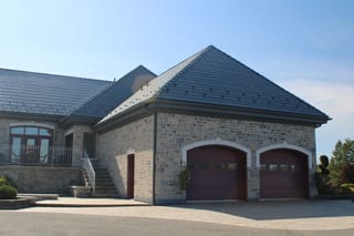Deep Charcoal Interlock Slate aluminum roof on a beige stone house with a dark roof in a suburban setting, Alexandria, Ontario