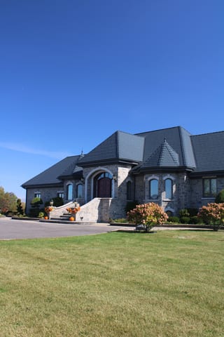 Deep Charcoal Interlock Slate aluminum roof on a grey stone home with a slate metal roof in a rural area, Alexandria, Ontario