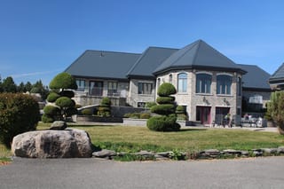 Deep Charcoal Interlock Slate aluminum roof on a stone colonial home with dormers on a tree-lined suburban, Alexandria, Ontario