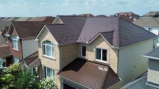 Aerial front view of a two-storey Colonial home in Ottawa with Interlock aluminum slate roofing in Colonial Brown, featuring multiple dormers and complex hip valleys.