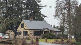 Black Interlock Cedar Shingle aluminum roof on a stone cottage with a metal roof in a rural mountain, Hood River, Oregon