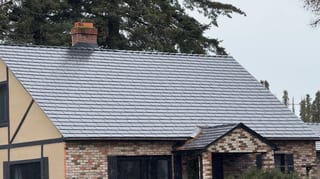 Black Interlock Cedar Shingle aluminum roof on a brown single-storey cottage with dormers in a forested, Hood River, Oregon