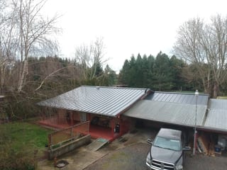 Deep Charcoal Interlock Standing Seam aluminum roof on a single-story home with a metal roof and attached garage, Scio, Oregon