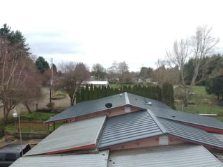 Deep Charcoal Interlock Standing Seam aluminum roof on a deep charcoal metal roof on a single-storey home in a, Scio, Oregon