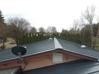 Deep Charcoal Interlock Standing Seam aluminum roof on a single-storey home with a metal roof in a forested rural, Scio, Oregon